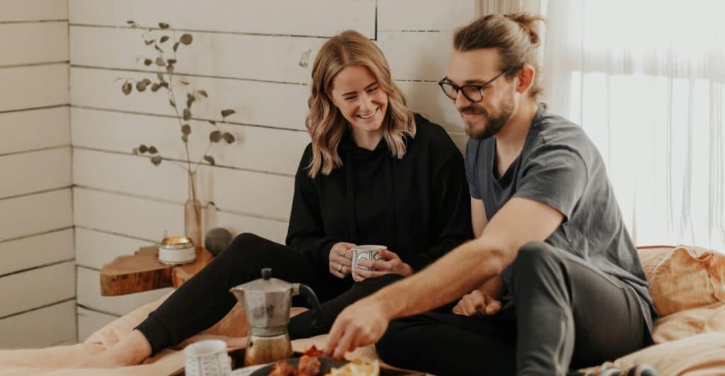 A couple enjoying breakfast in bed.