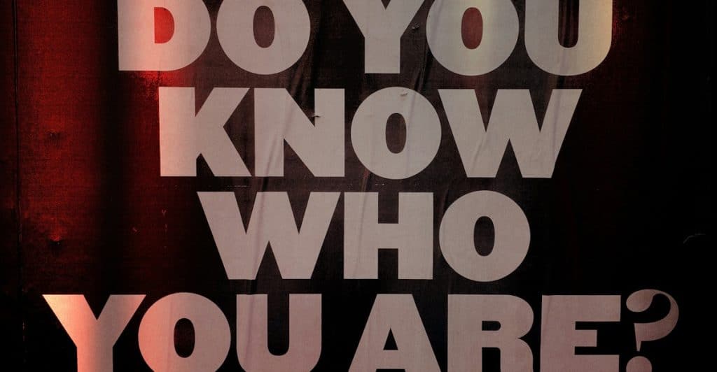 Large, bold white text on a dark, textured background asking "DO YOU KNOW WHO YOU ARE?" with glowing red undertones.