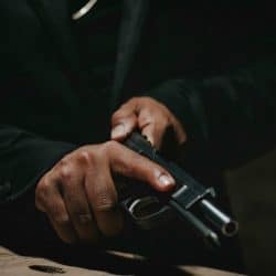 Two hands holding a black handgun, ready to fire