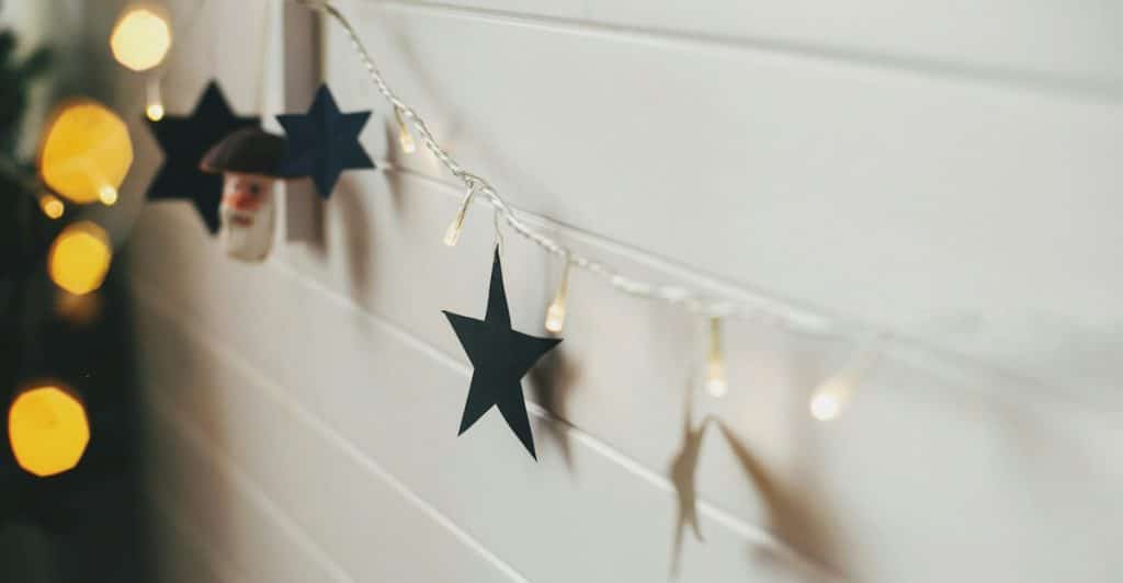 Wall decorated with string lights and star cutouts.