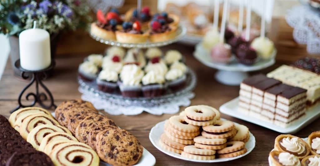Table with various sweet snacks and desserts.