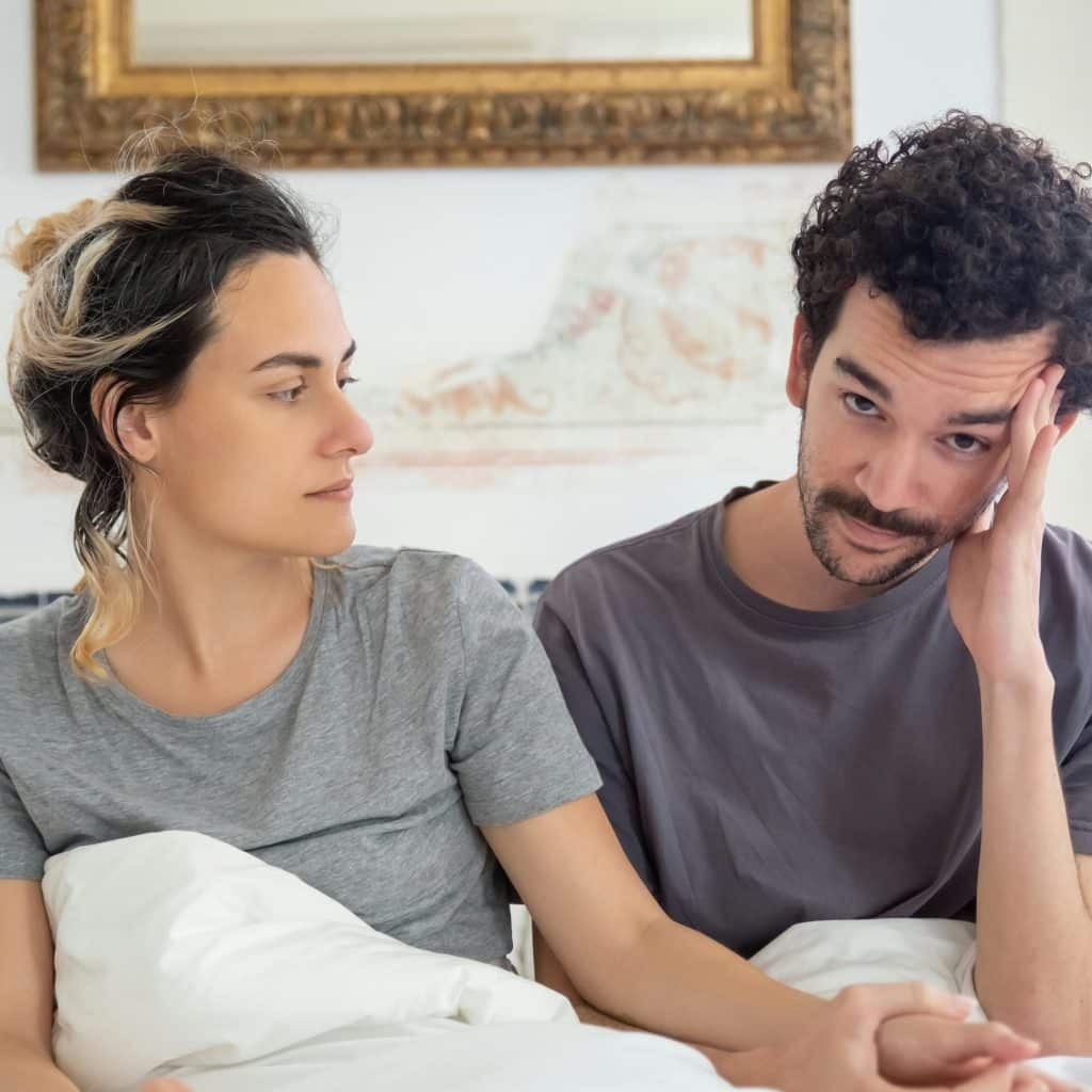 A man with a thoughtful expression, looking down, suggesting contemplation or sadness.