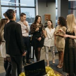 A group of people standing and talking at what appears to be a party or social gathering