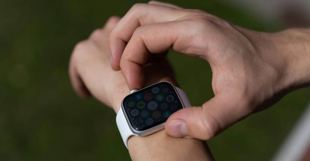 A person is looking at a smartwatch on their wrist outdoors.