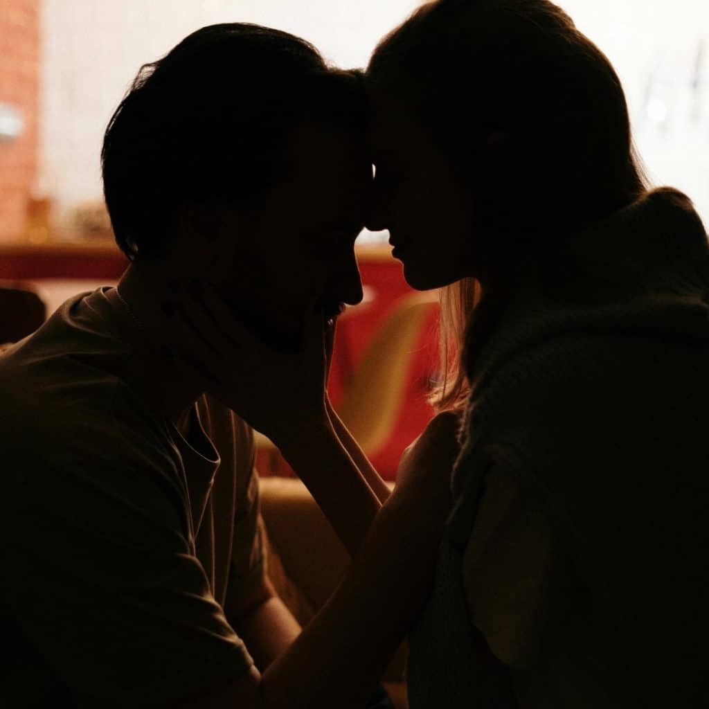 A silhouetted couple with their foreheads touching, symbolizing intimacy and closeness