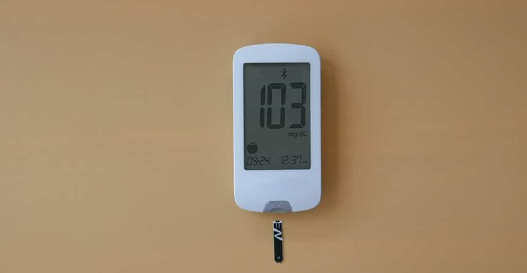 A white digital smart thermometer with a reading of "103" and a connected probe.
