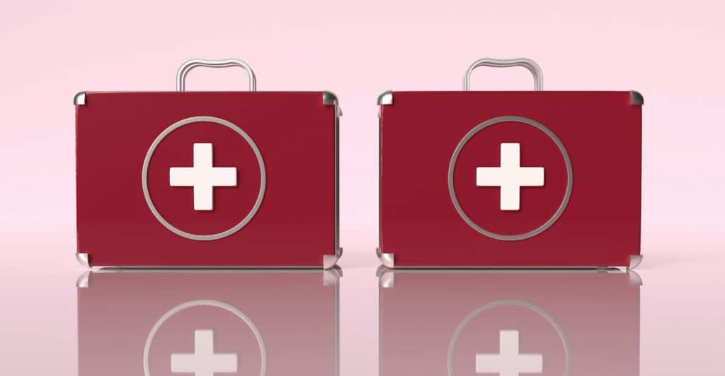 Two red first aid cases with white cross symbols and reflections.