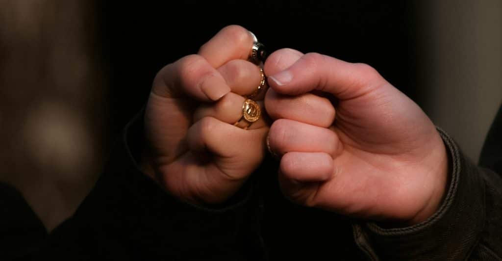 Two hands in a fist-bump, one wearing a ring