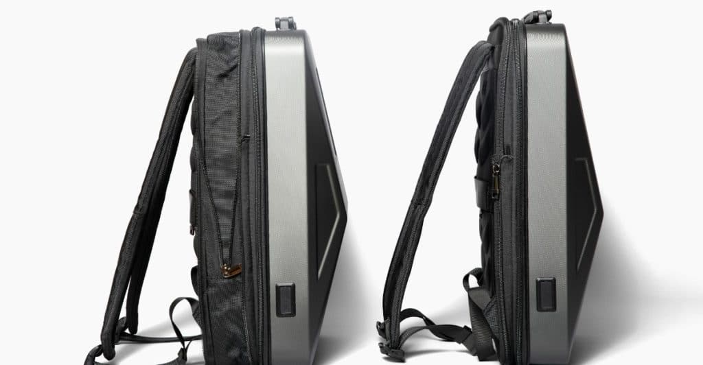 Two dark gray smart backpacks with hard shells standing upright against a white background.