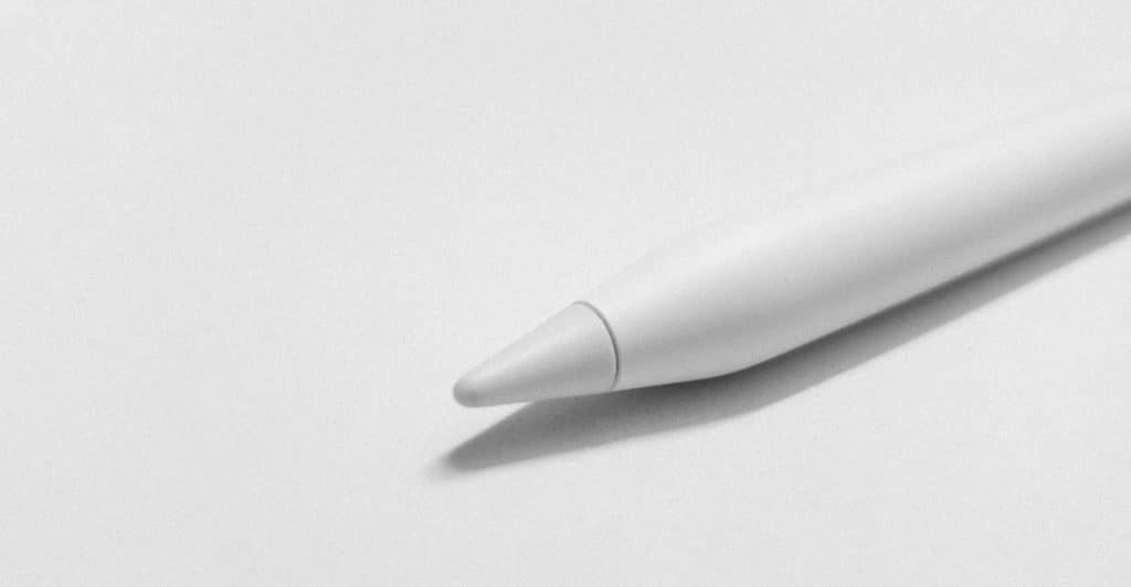 The tip of a white smart pen resting on a plain white surface.