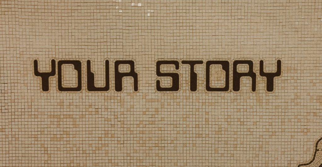 The words "YOUR STORY" are spelled out in dark tiles on a light-colored mosaic wall.