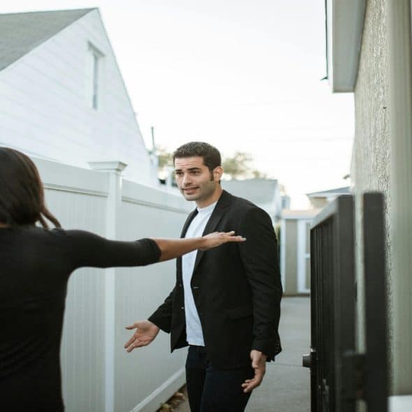 Couple wearing in black are arguing while they are off to work.