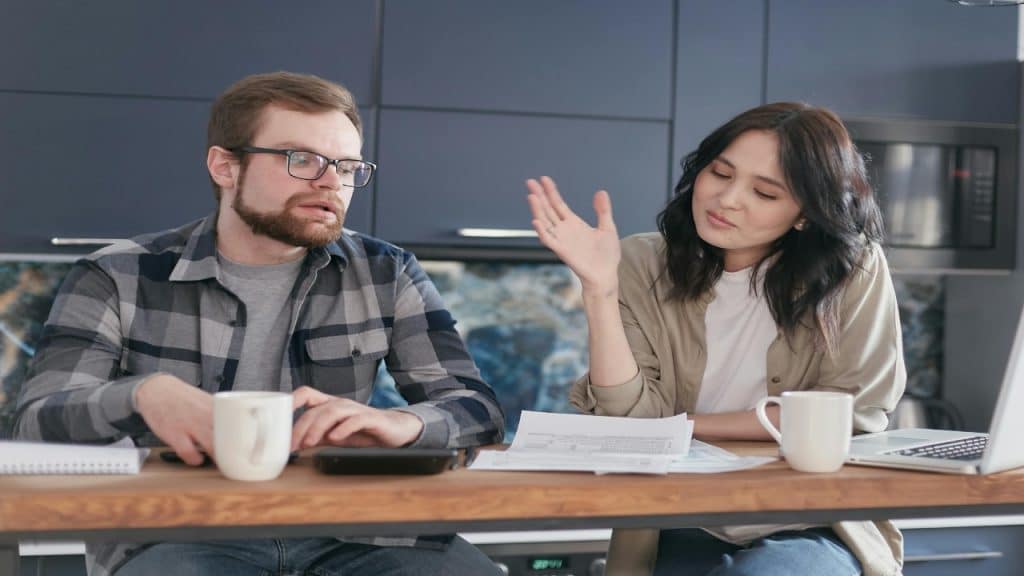 A man sits in silence as her partner vents, showing how anger breaks down emotional trust in conversation.