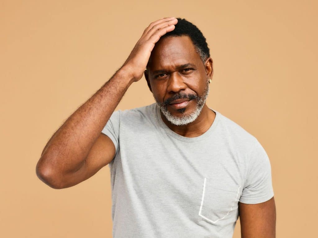 A picture of a man with hand on his head