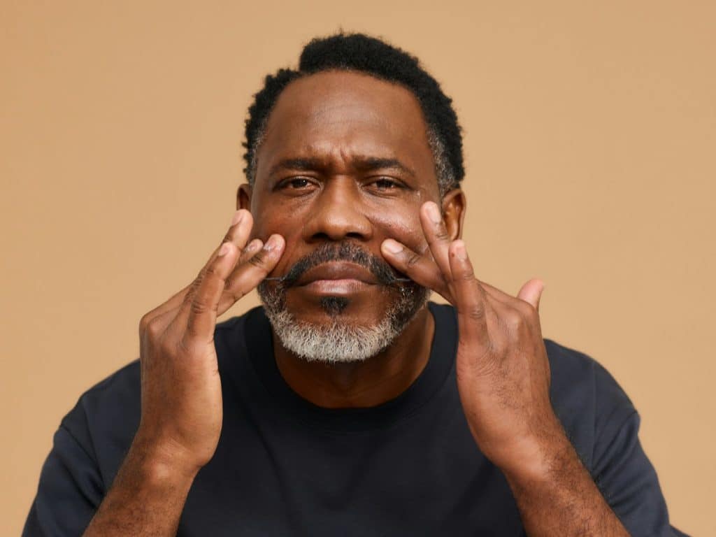 A man touching his face