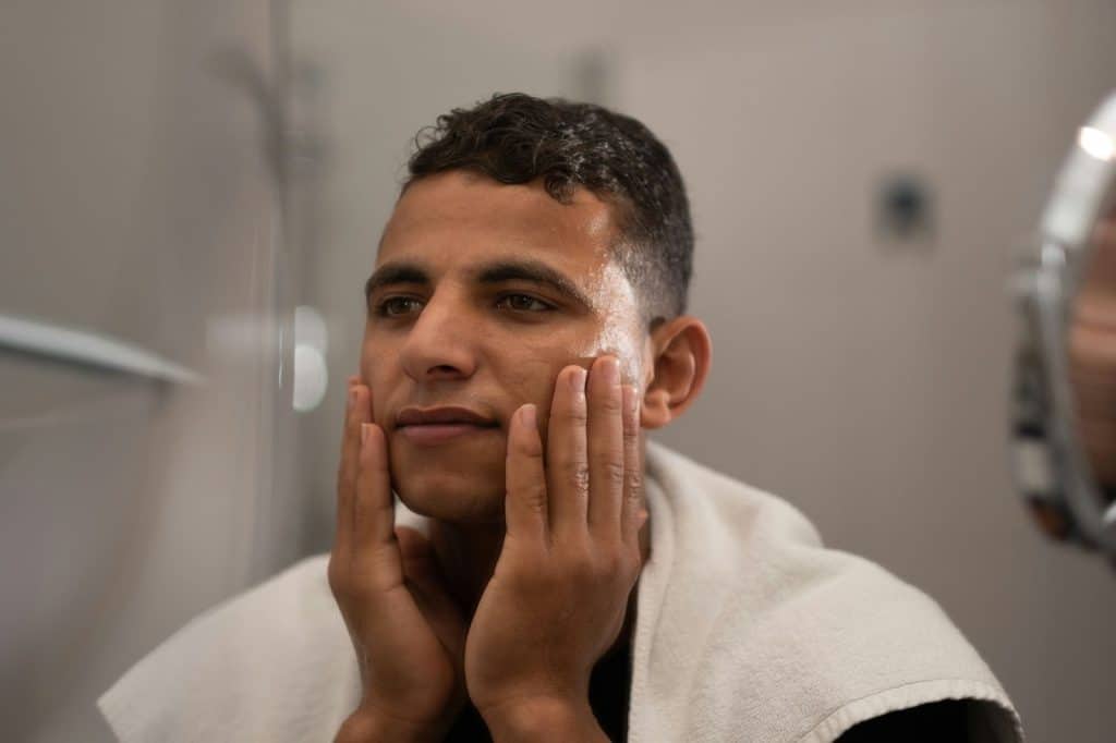 A man touching his clean face