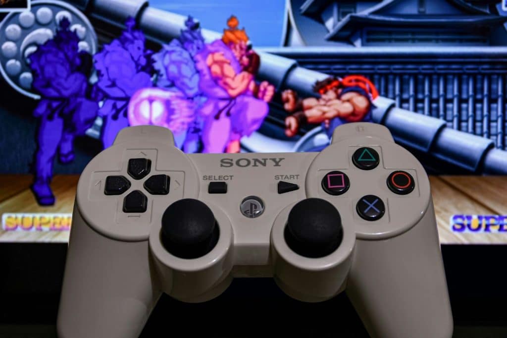 A game controller and in the background is the street fight game.