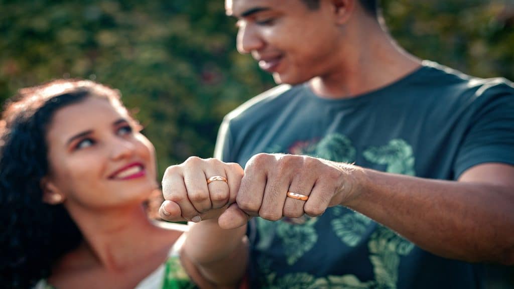 A couple shows their wedding rings together.