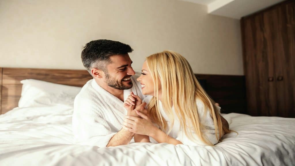 A couple shares a smile after waking up in the morning.