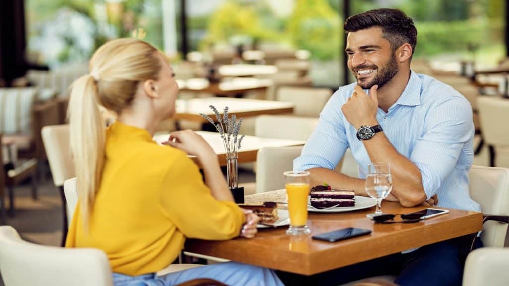 A couple shares a happy conversation inside a restaurant.