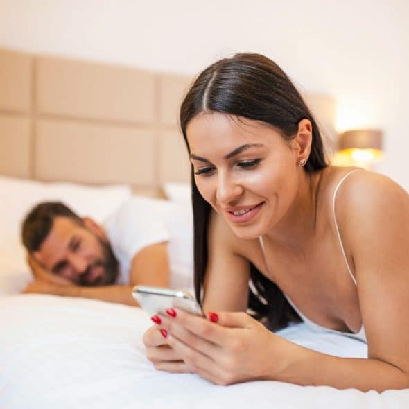 A man secretly looking at her girlfriend’s phone