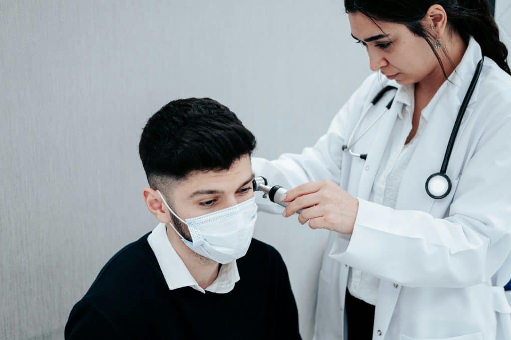 A man wearing a mask while having a check-up