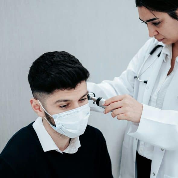 A man wearing a mask while having a check-up