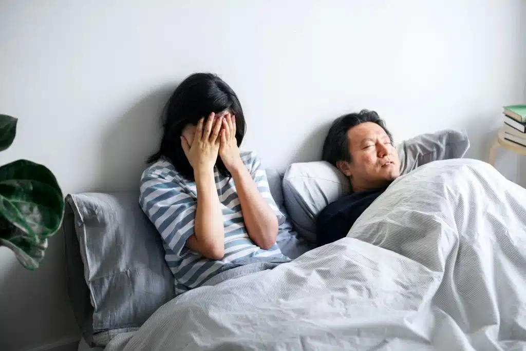 A man sleeping and a woman covering her face