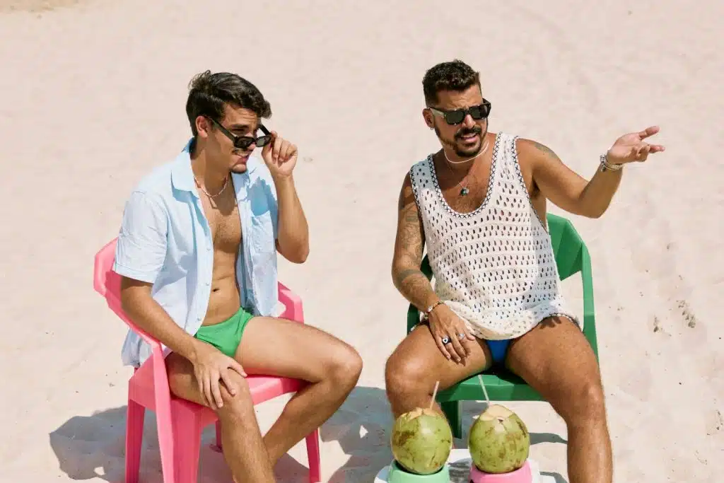 2 men sitting and talking at the beach.