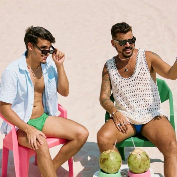 2 men sitting and talking at the beach.