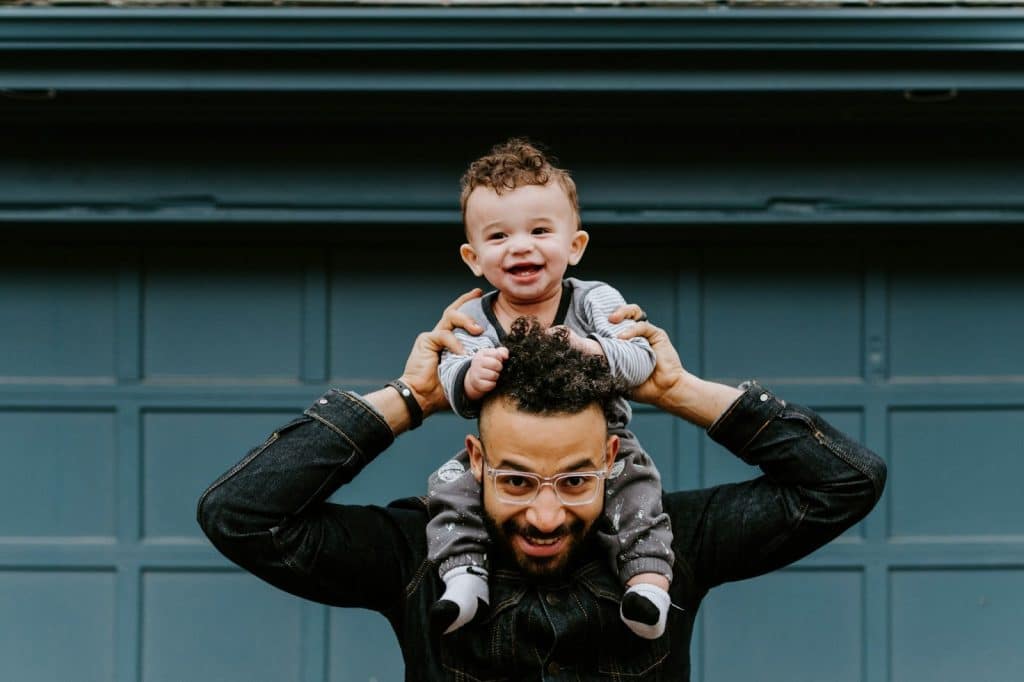 A picture of a Dad carrying a child on his neck