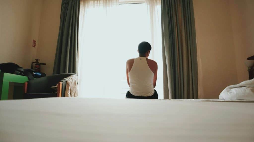 A man looks out a window, reflecting on whether his relationship is still growing.