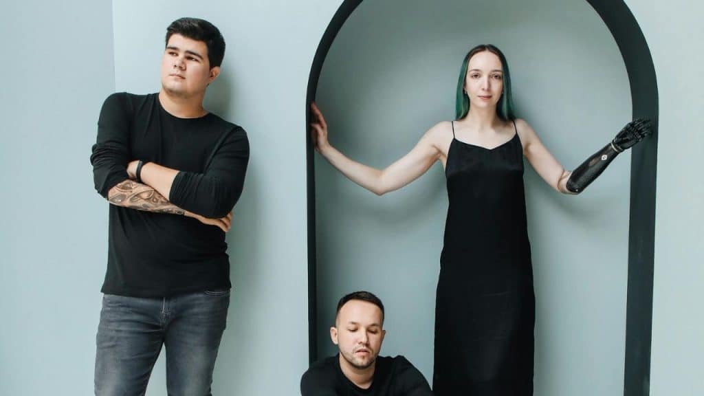 Two men look visibly confused while the woman is standing on the side.