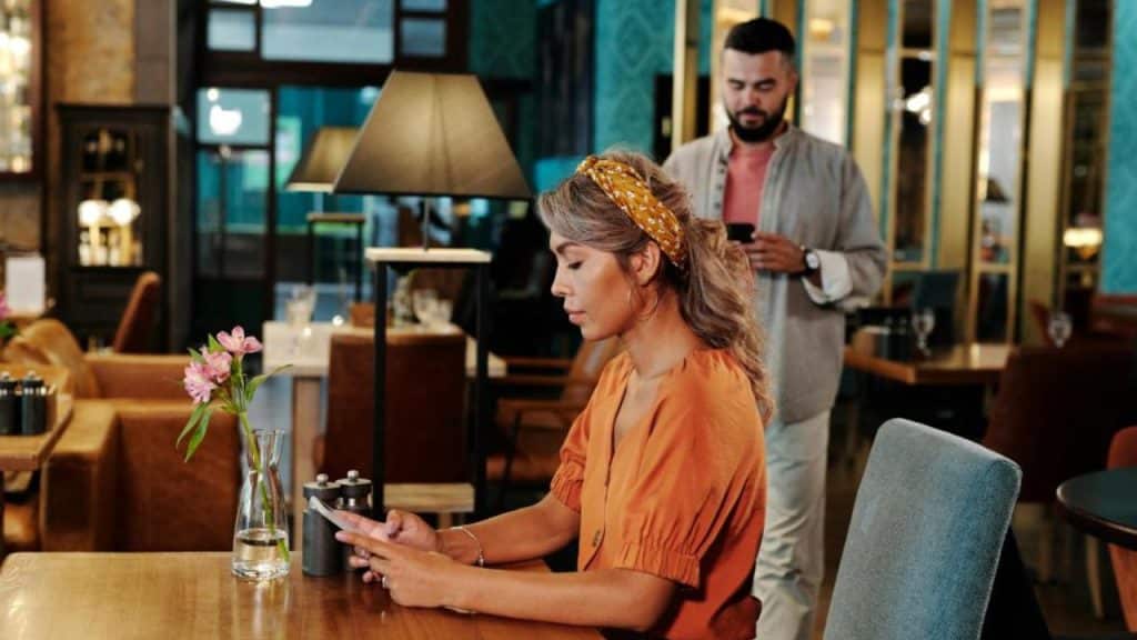A man prepares coffee while his partner ignores him.