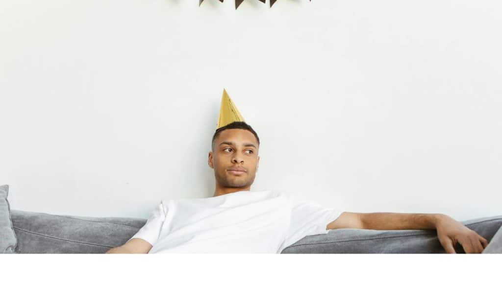 A man stares into space while sitting on the couch, emotionally absent.