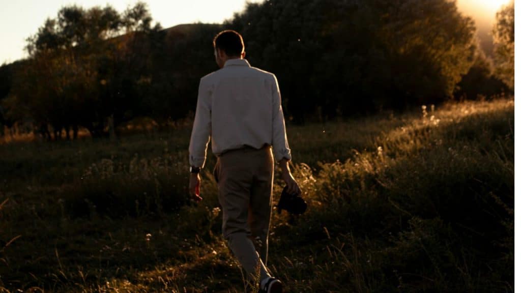A man walks into the distance on an open road, choosing a new path.