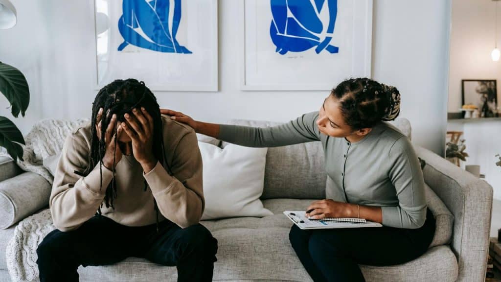 A man and a woman in a cozy, low stress environment helping to ease emotional tension.