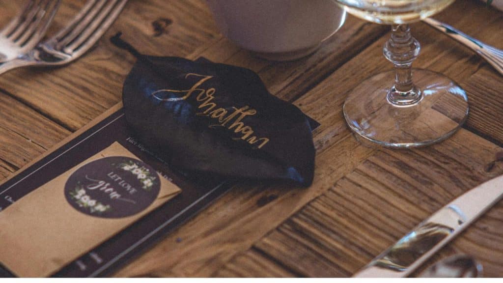 Custom cocktail placed next to a handwritten name card on a table.