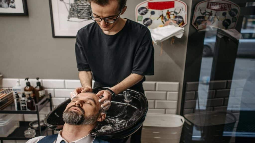 A man being shampooed at a salon.
