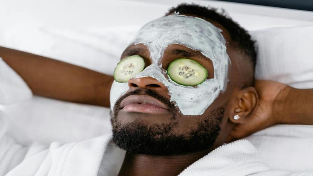 A man wearing a face mask and sliced cucumbers.
