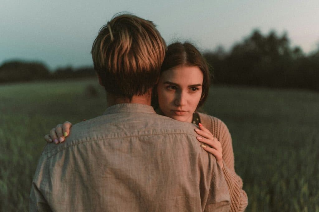A picture of a man’s back while hugging a woman