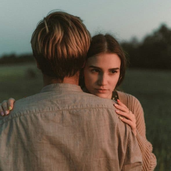 A picture of a man’s back while hugging a woman