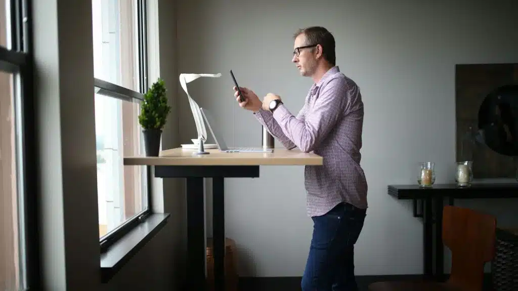 A picture of a man standing using his phone