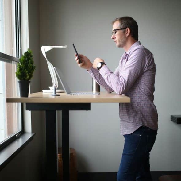 A picture of a man standing using his phone