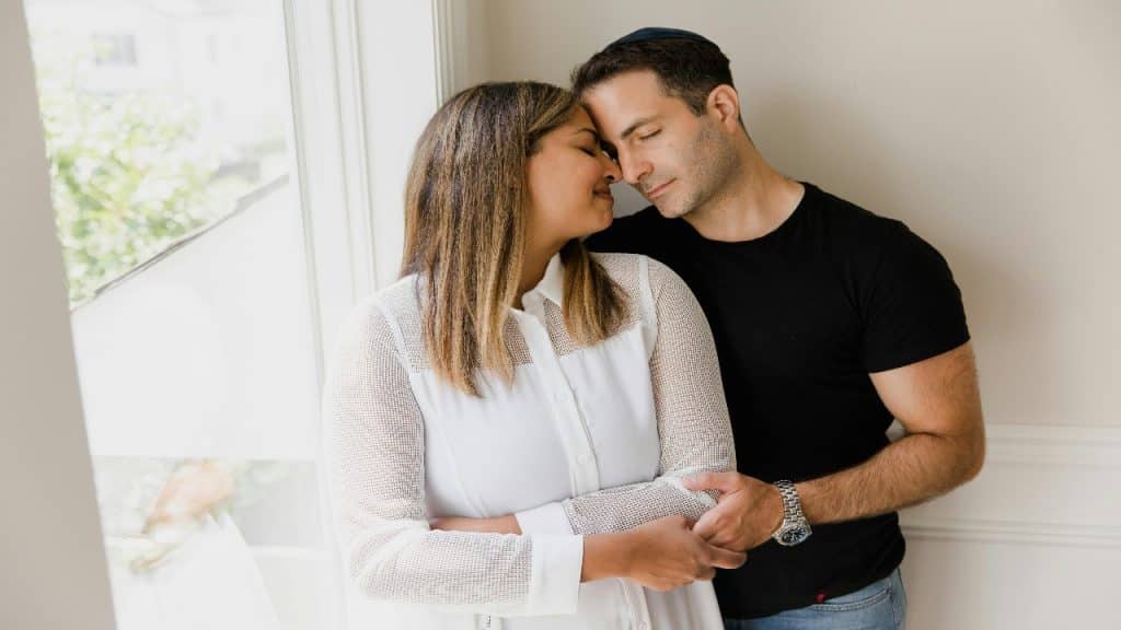 A couple gently leaning their foreheads together in an intimate and loving moment.