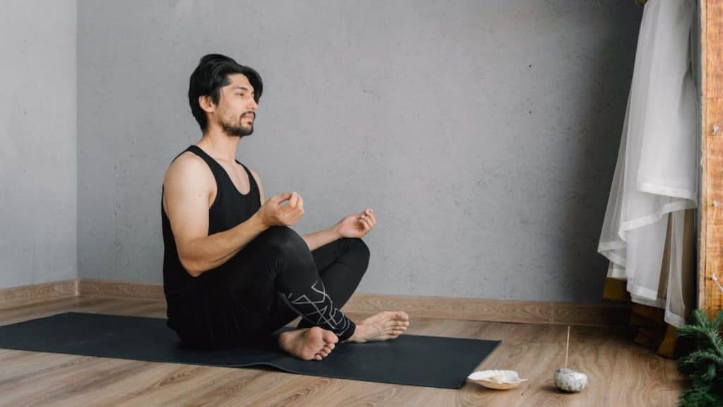 Man practicing mindfulness indoors to reduce stress and belly fat.