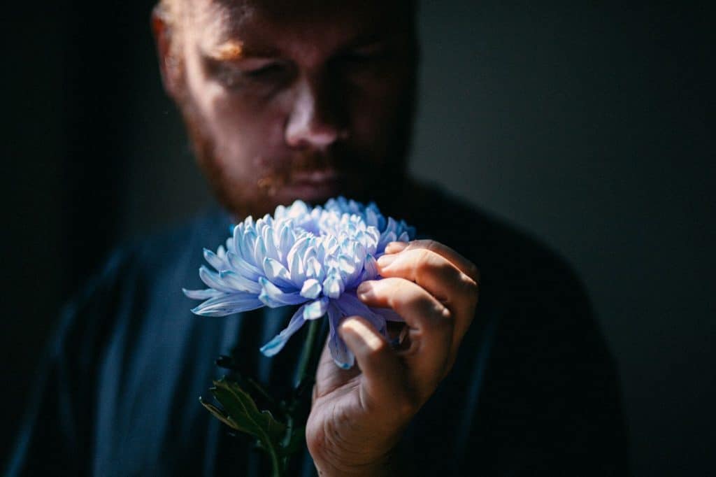 A man holding a flower that represents “growth” 