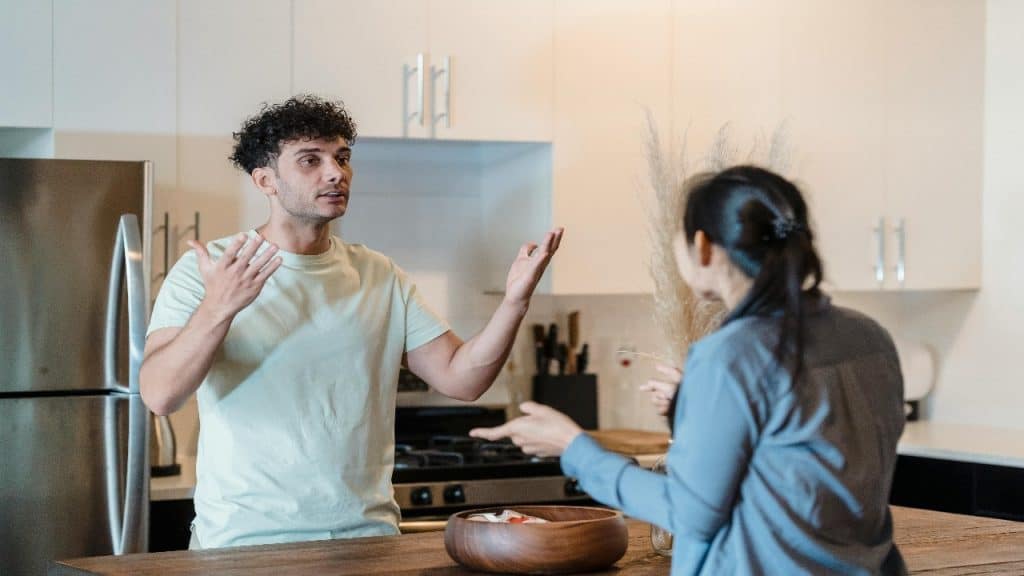 A man and woman are having a heated discussion in a modern kitchen.