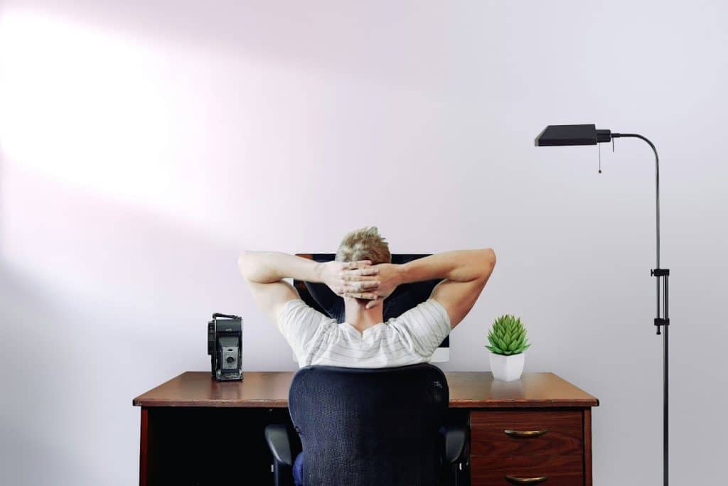 A man stretching while facing his table