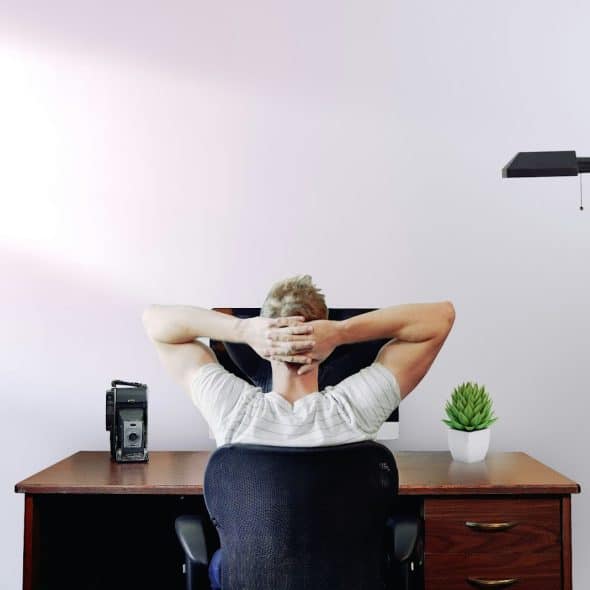 A man stretching while facing his table